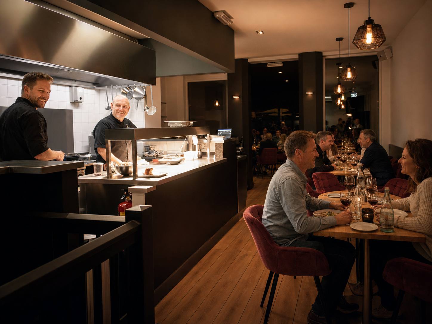 Chefs at the open kitchen pass with guests dining at Graham’s Kitchen